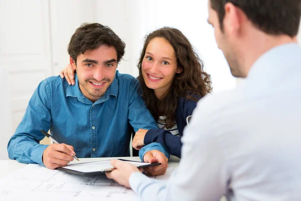 Joven pareja atractiva firma contrato — Foto de Stock