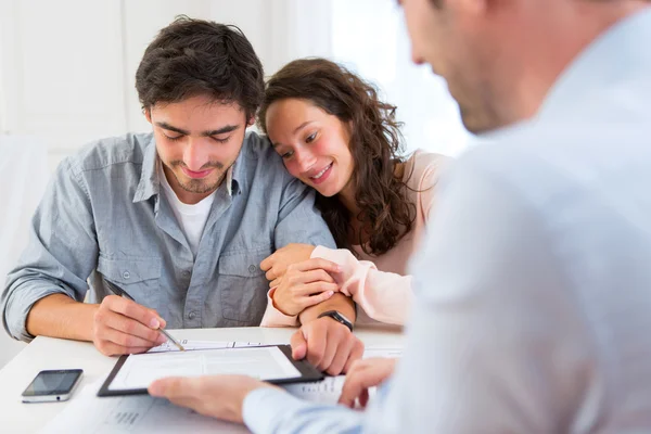 Young attractive couple signing contract — Stock Photo, Image