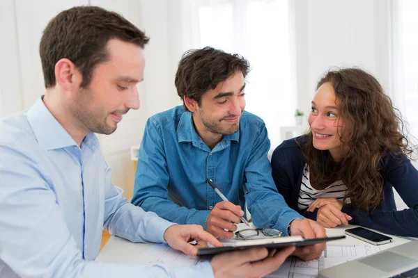 Young attractive couple signing contract — Stock Photo, Image