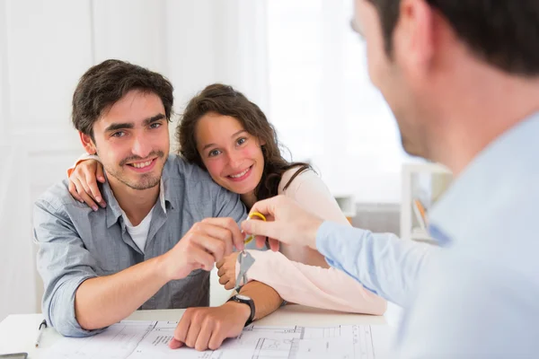 Real estate handing over keys to couple — Stock Photo, Image