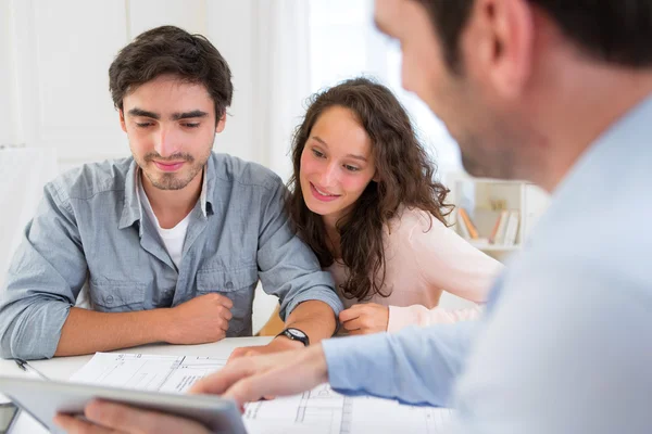 Young relaxed couple meeting a real estate agent — Stock Photo, Image