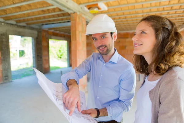 Mujer joven y arquitecto en obra — Foto de Stock