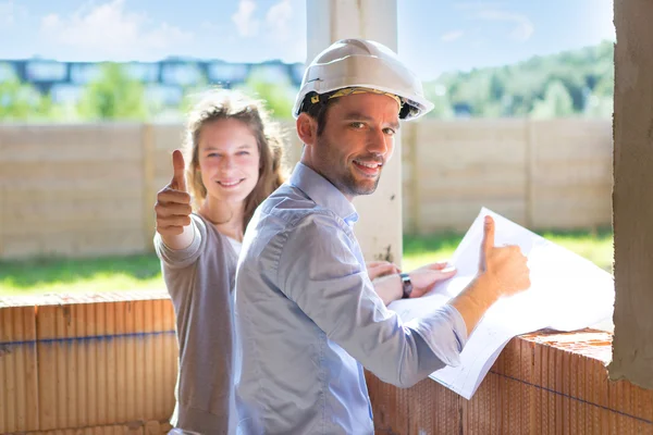 Mujer joven y arquitecto en obra — Foto de Stock