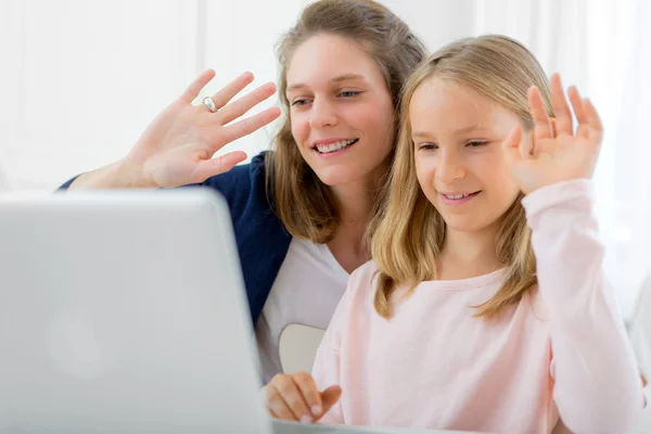 Attractive woman and little sister videocalling — Stock Photo, Image