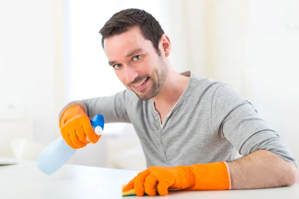 Молодой привлекательный мужчина убирает свою квартиру — стоковое фото
