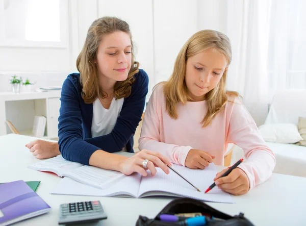 Woman helping out her little sister for homework Stock Photo