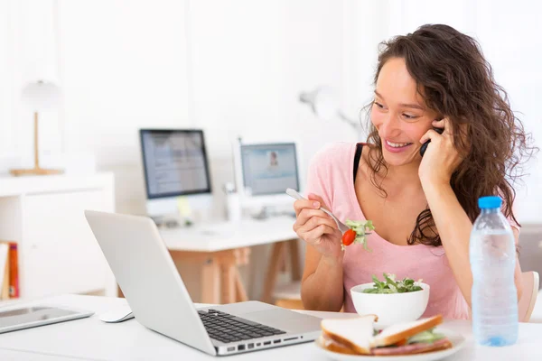 Joven estudiante atractivo comiendo ensalada mientras llama —  Fotos de Stock