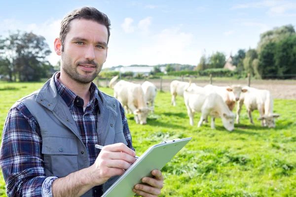 Giovane agricoltore attraente che lavora in un campo — Foto Stock