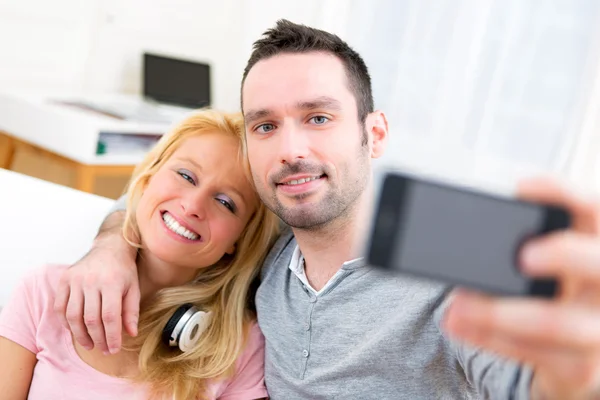 Jovem casal atraente se divertindo fazendo selfie — Fotografia de Stock