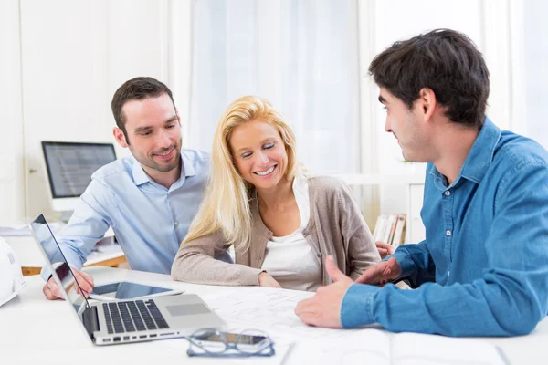 Jonge ernstige paar vergadering een onroerende goederenagent — Stockfoto