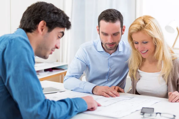 Young serious couple meeting a real estate agent — Stock Photo, Image