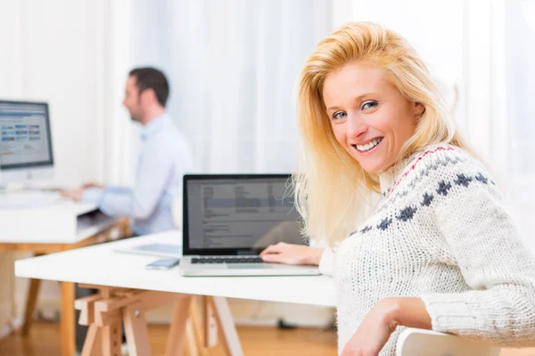 Junge attraktive blonde Frau arbeitet am Computer — Stockfoto