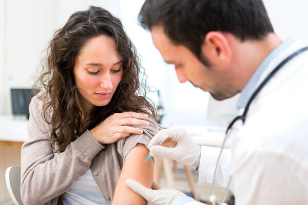 Young attractive woman being vaccinated Stock Photo