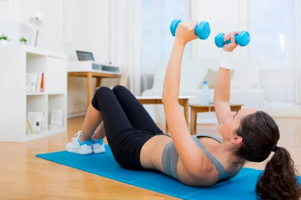 Jovem menina atraente fazendo exercício em casa — Fotografia de Stock