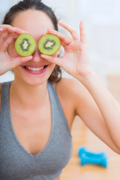 Atractiva mujer deportiva comiendo kiwi después del deporte — Foto de Stock