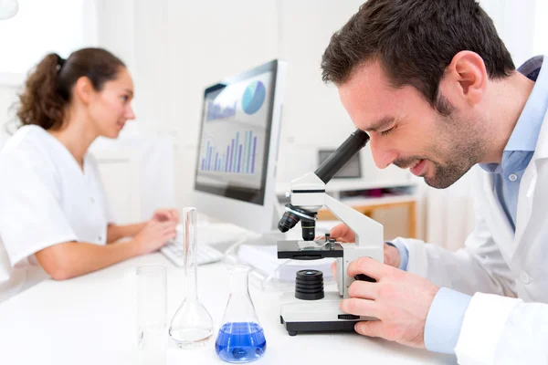 Cientista e sua assistente em um laboratório — Fotografia de Stock