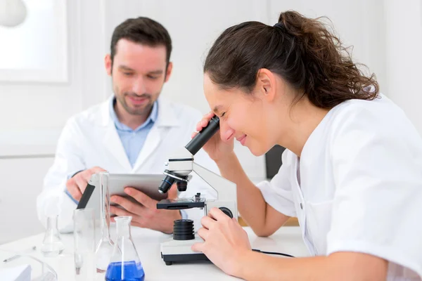 Wetenschapper en zijn assistent in een laboratorium — Stockfoto