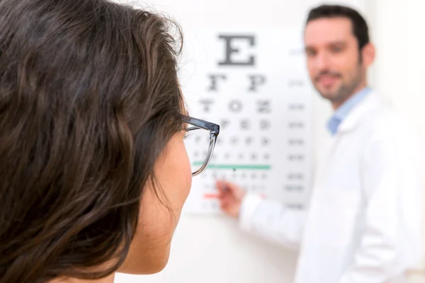 Jeune femme séduisante faisant un test opticien — Photo