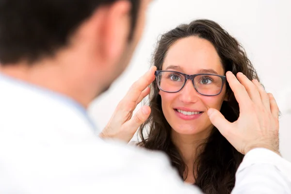 Jovem mulher atraente tentando óculos w optician — Fotografia de Stock