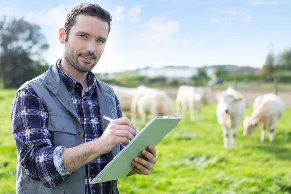 Giovane agricoltore attraente che lavora in un campo — Foto Stock