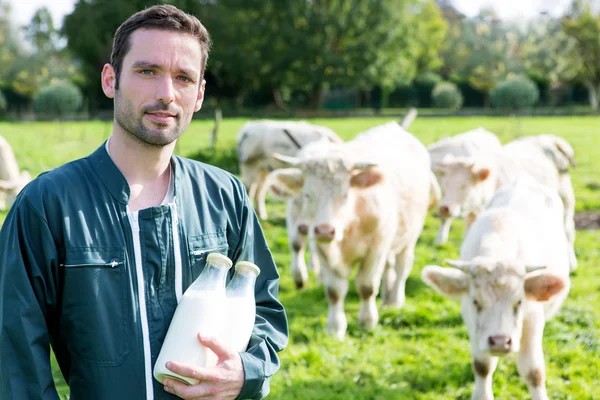 Jovem agricultor atractivo com garrafa de leite — Fotografia de Stock