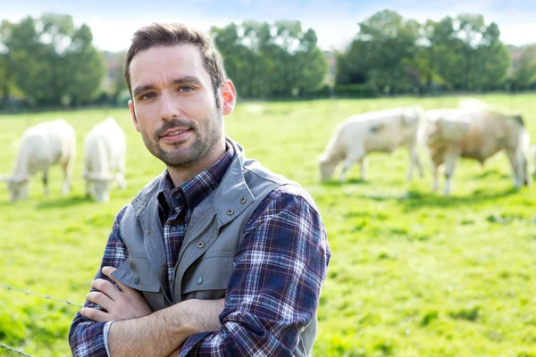 Giovane agricoltore attraente che lavora in un campo — Foto Stock