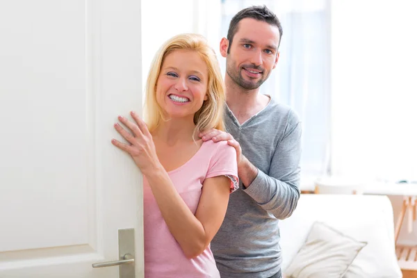 Young attractive couple welcoming you in his house — Stock Photo, Image