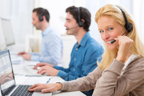 Ung attraktiv kvinna som arbetar i ett callcenter — Stockfoto