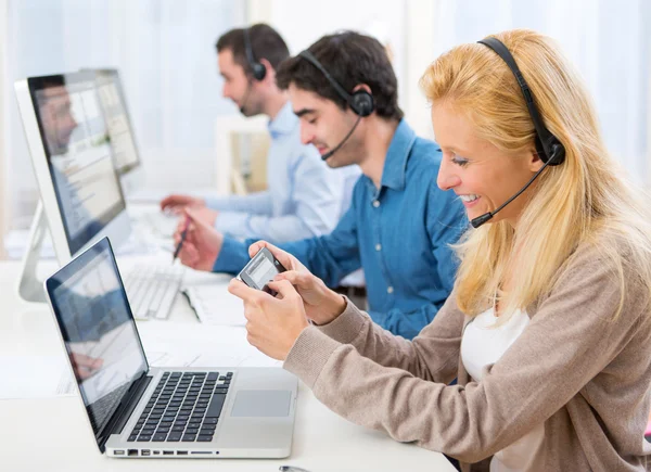 Jeune femme attrayante envoyer du texte au travail — Photo