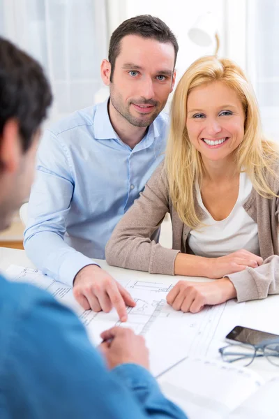 Jeune couple sérieux rencontrant un agent immobilier — Photo