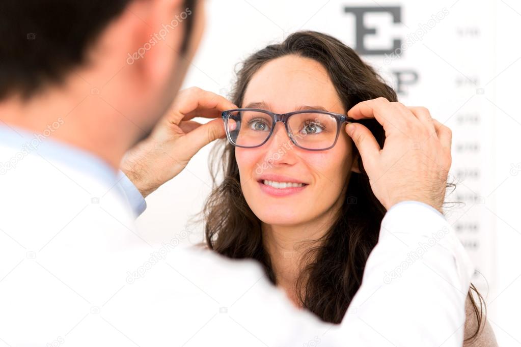 Young attractive woman trying glasses w optician