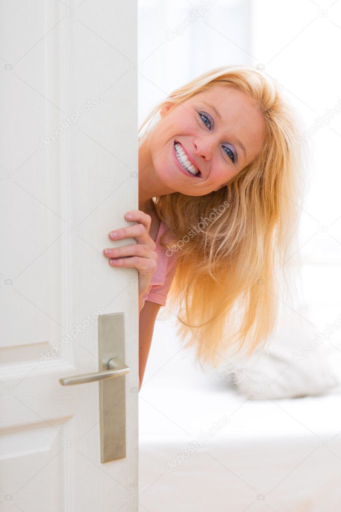 Young attractive woman welcoming you in her house