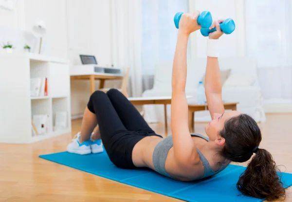 Jovem menina atraente fazendo exercício em casa — Fotografia de Stock