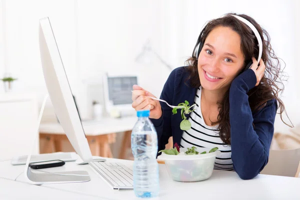 Young attractive student listenning music while eating — Stock Photo, Image
