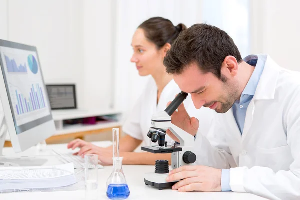 Cientista e sua assistente em um laboratório — Fotografia de Stock