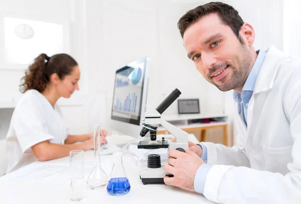 Científica y su asistente en un laboratorio — Foto de Stock