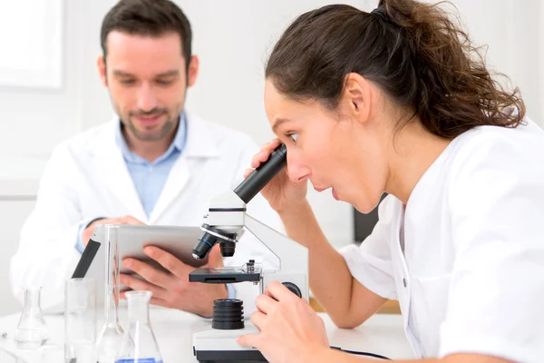 Wetenschapper en zijn assistent in een laboratorium — Stockfoto