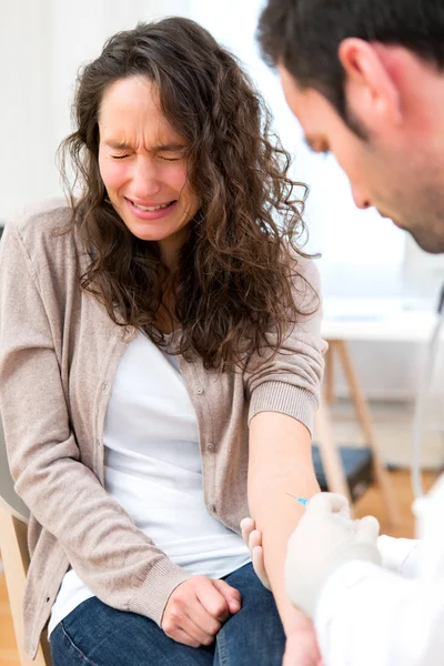 Aantrekkelijke jonge vrouw bang door injectie — Stockfoto