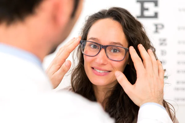 Young attractive woman trying glasses w optician — Stock Photo, Image