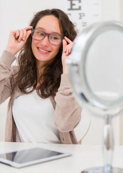 Jovem mulher atraente tentando novos óculos — Fotografia de Stock