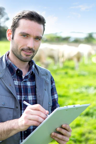 Young attractive farmer working in a field — Stock Photo, Image