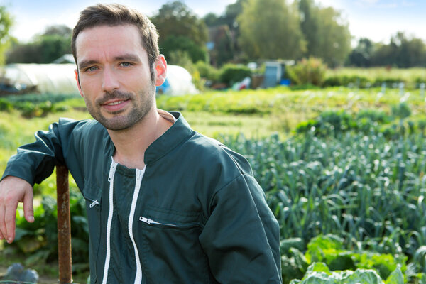 Young attratcive farmer in front of garden