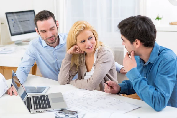 Young serious couple meeting a real estate agent — Stock Photo, Image