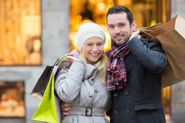 Jonge aantrekkelijke paar met shopping tassen — Stockfoto