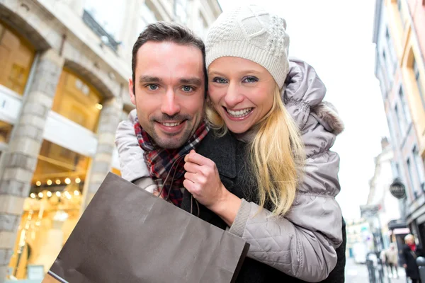 Jovem casal atraente se divertindo enquanto faz compras — Fotografia de Stock