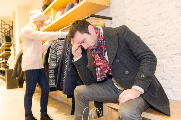 Jovem homem casual esperando enquanto sua esposa faz compras — Fotografia de Stock