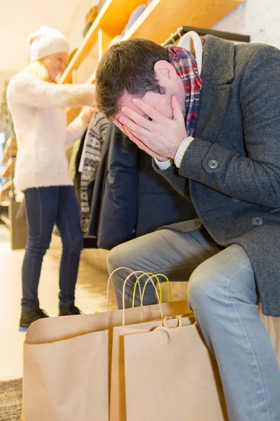 Jovem homem casual esperando enquanto sua esposa faz compras — Fotografia de Stock