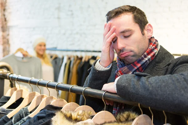 Jovem homem casual esperando enquanto sua esposa faz compras — Fotografia de Stock