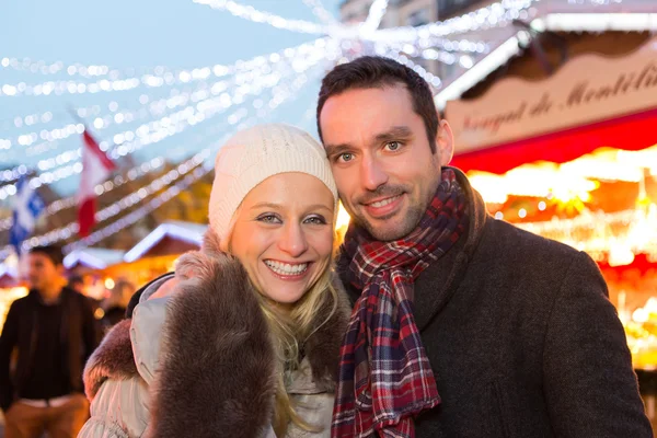 Unga attraktiva paret i en julmarknad — Stockfoto