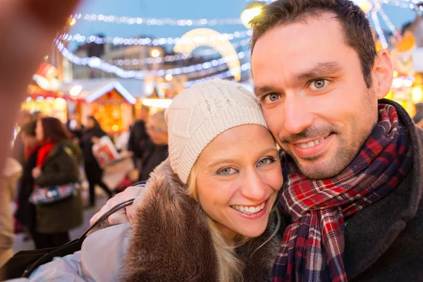 Mladý atraktivní pár na vánoční trhu — Stock fotografie